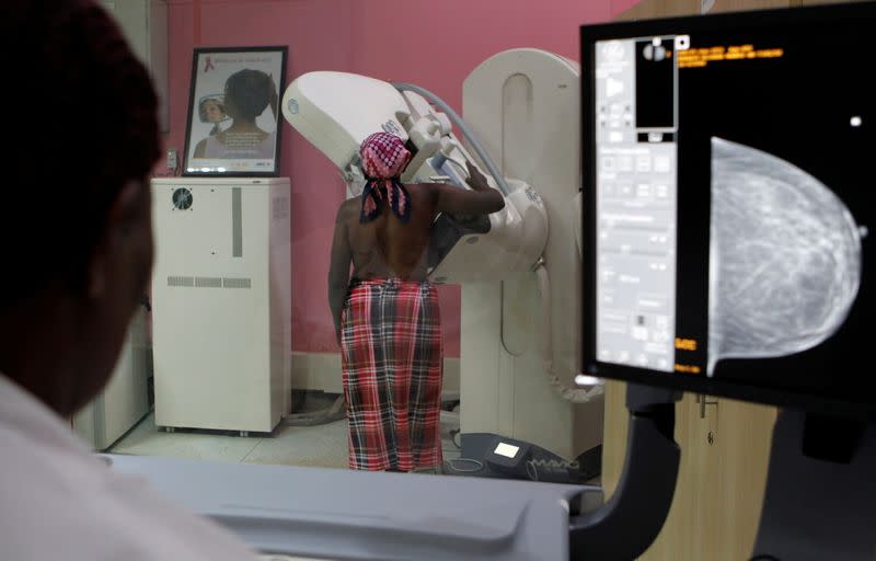 FILE PHOTO: A patient is seen through the glass as she undergoes a mammogram X-ray picture of the breast to look for early signs of breast cancer in the radiology unit at the Kenyatta National Hospital in Nairobi