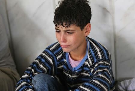 A youth who survived from what activists say is a gas attack cries as he takes shelter inside a mosque in the Duma neighbourhood of Damascus, Syria August 21, 2013. REUTERS/Mohamed Abdullah/Files