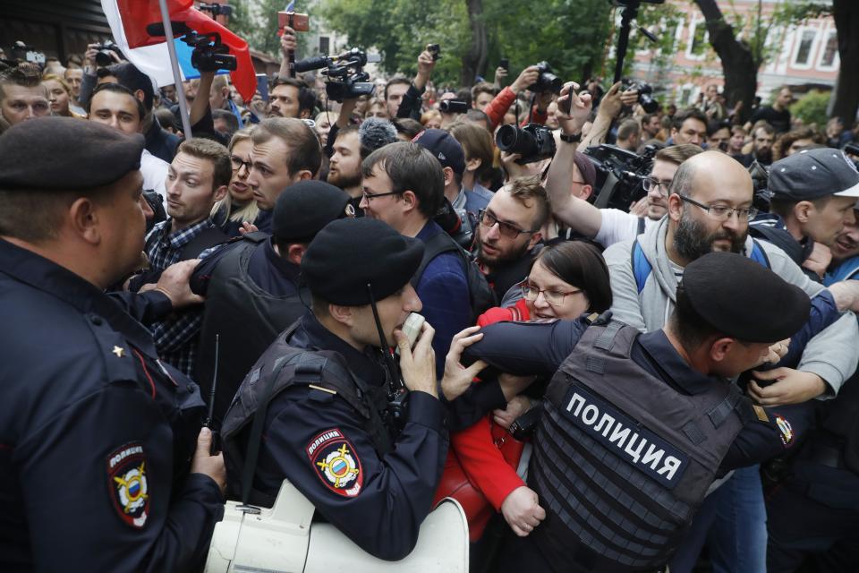 Police block demonstrators during a protest in Moscow, Russia, Sunday, July 14, 2019. Around 1,000 people have gathered in central Moscow to demand that opposition candidates be included on ballots for an upcoming city parliament election in September. (AP Photo/Pavel Golovkin)