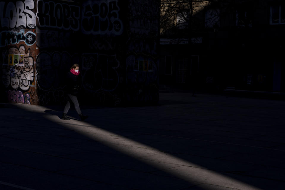 A woman wearing an FFP2 face mask to curb the spread of COVID-19 walks in Madrid, Spain, Wednesday, Jan. 12, 2022. Italy, Spain and other European countries are re-instating or stiffening mask mandates as their hospitals struggle with mounting numbers of COVID-19 patients. (AP Photo/Manu Fernandez)