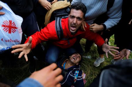 A migrant screams on the ground as migrants tried to cross the Greek-Macedonian border near the Greek village of Idomeni November 26, 2015. REUTERS/Yannis Behrakis