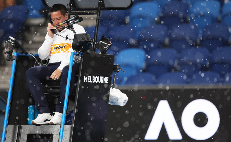 An umpire, pictured here speaking on the phone during a suspension due to the rain at the Australian Open.