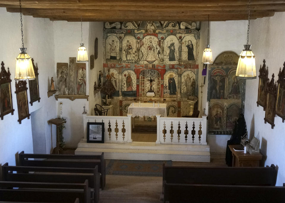 The newly preserved wooden 1810s reredo or altarpiece is seen in the Holy Rosary Mission Church in the ridgetop village of Truchas, New Mexico, Sunday, April 16, 2023. Local volunteers worked to save the 1760s adobe church and brought in master santero Felix Lopez – an artist trained in New Mexico's centuries-old tradition of religious sculpture and painting – to help clean and preserve the profusely decorated altarpiece. (AP Photo/Giovanna Dell'Orto)