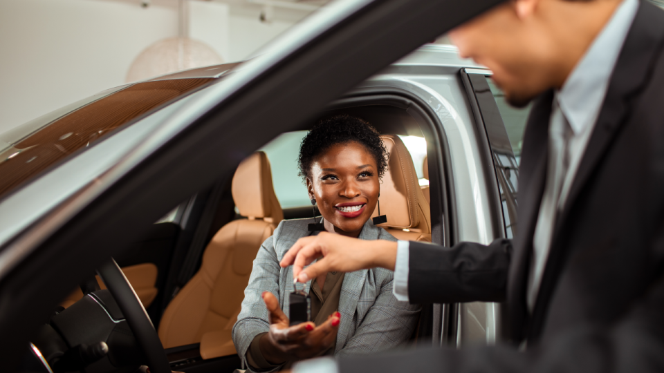 Person purchasing a vehicle and being handed the keys by a sales rep.