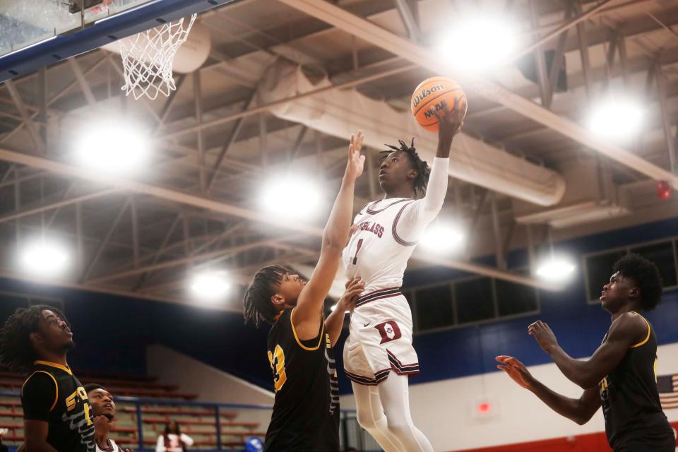 Douglass High’s Taquez Butler (1) lays up the ball against TACA Academy’s TJ Burch (33) in a basketball game during the ‘Battle in the Bluff’ tournament on Friday, December 07, 2023 at Bartlett High School in Bartlett,Tenn.