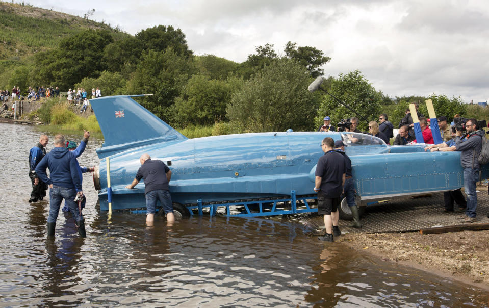 The restored Bluebird K7, which crashed killing pilot Donald Campbell in 1967, takes to the water for the first time in more than 50 years off the Isle of Bute on the west coast of Scotland, Saturday Aug. 4, 2018. The famed jet boat Bluebird has returned to the water for the first time since a 1967 crash that killed pilot Donald Campbell during a world speed-record attempt. Watched by Campbell's daughter Gina Campbell, the restored Bluebird was lowered Saturday into Loch Fad on Scotland's Isle of Bute, where it will undergo low-speed tests.(David Cheskin/PA via AP)