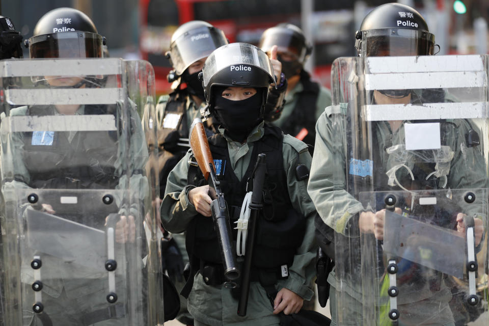 Riot policemen stand watch as pro-democracy protesters stage a rally in Hong Kong, Sunday, Dec. 1, 2019. Pro-democracy protesters renewed pressure on the Hong Kong government Sunday with three separate marches, appealing to President Donald Trump for help and demanding that police stop using tear gas.(AP Photo/Vincent Thian)