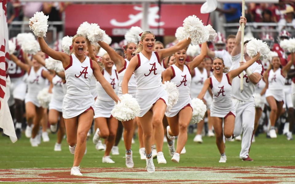 The Alabama cheerleaders run onto the field on Sept. 9, 2023, ahead of the Crimson Tide football team at Bryant-Denny Stadium.