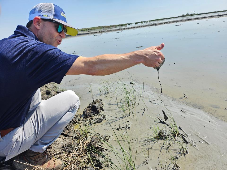 CPRA Executive Director Glenn Ledet Jr. shows off sediment pumped from the bottom of Lake Borgne to the $114 million marsh restoration project roughly 10 miles east of New Orleans, May 16, 2024.
