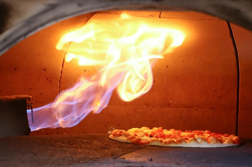 flame shoots over pizza in oven
