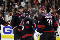 Carolina Hurricanes goaltender Frederik Andersen (31) is congratulated after his victory over the New York Islanders by teammates Jake Guentzel (59) and Jordan Staal (11) during the third period in Game 1 of an NHL hockey Stanley Cup first-round playoff series in Raleigh, N.C., Saturday, April 20, 2024. (AP Photo/Karl B DeBlaker)