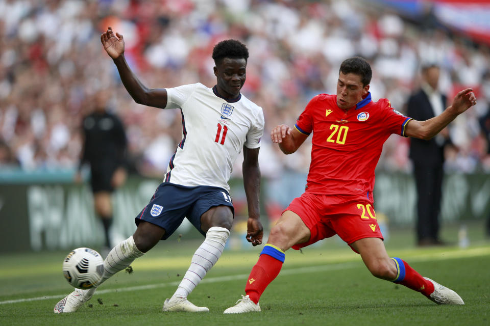 Andorra's Max Llovera tackles England's Bukayo Saka, left, during the World Cup 2022 group I qualifying soccer match between England and Andorra at Wembley stadium in London, Sunday, Sept. 5, 2021. (AP Photo/Ian Walton)