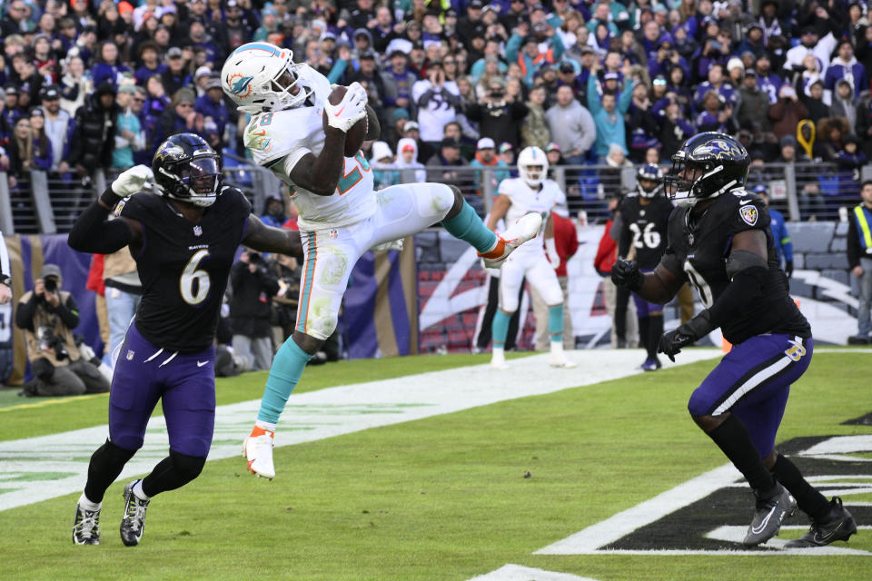 Miami Dolphins running back De'Von Achane (28) catches a touchdown pass as Baltimore Ravens linebacker Patrick Queen (6) defends during the second half of an NFL football game in Baltimore, Sunday, Dec. 31, 2023. (AP Photo/Nick Wass)