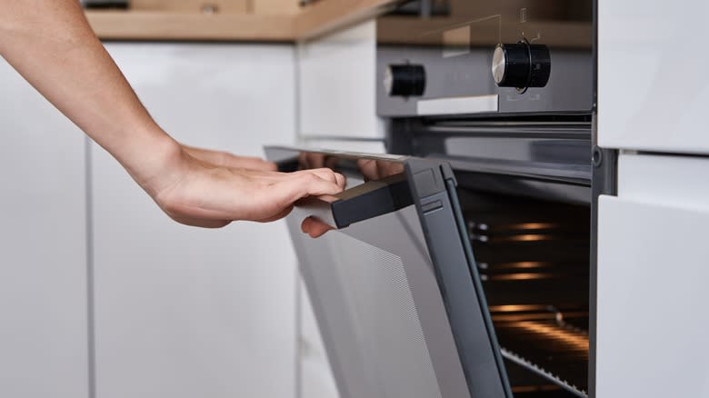 person opening oven door