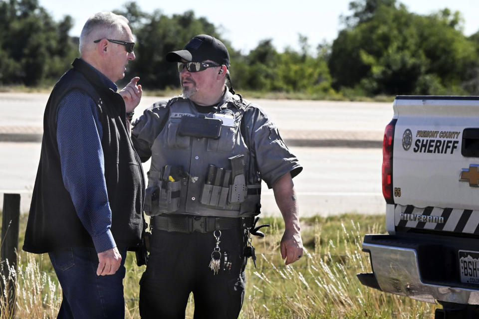 Fremont County Sheriff Allen Cooper, left, talks a deputy at the road leading to the Return to Nature Funeral Home in Penrose, Colo. Thursday, Oct. 5, 2023. Authorities said Thursday they were investigating the improper storage of human remains at a southern Colorado funeral home that performs “green” burials without embalming chemicals or metal caskets. (Jerilee Bennett/The Gazette via AP)