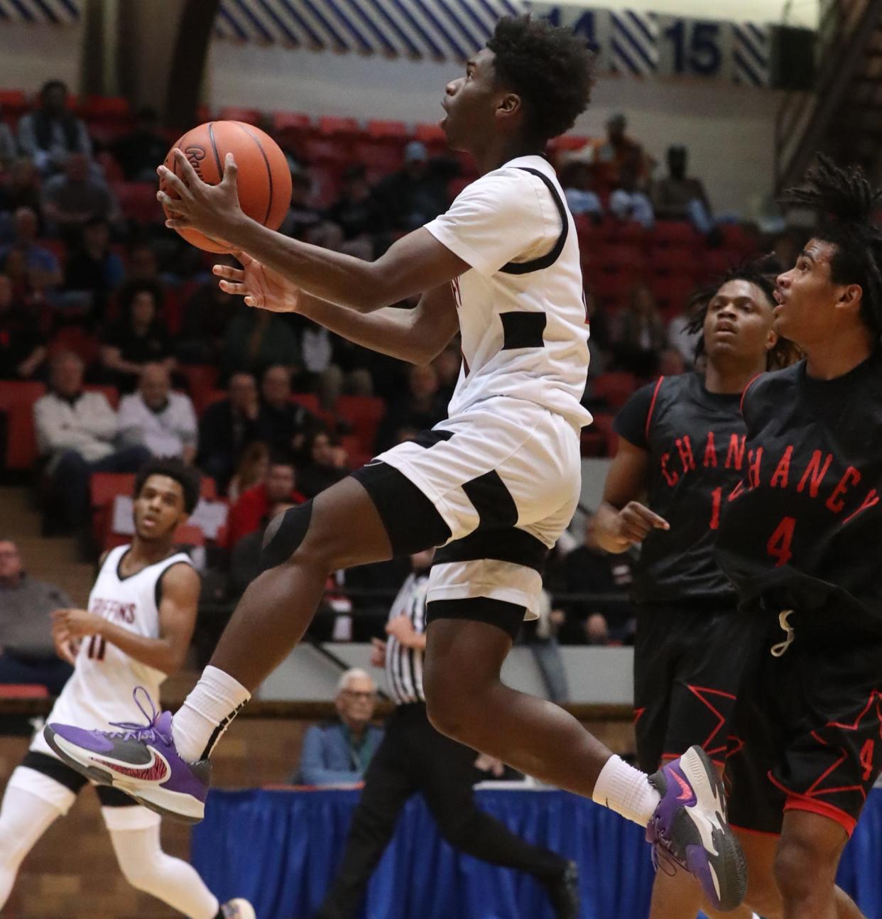 Buchtel's Qi'Marreon Marks goes to the hoop past Chaney's Jason Hewlett and Luis Febres during a Division II regional semifinal March 9 in Canton.
