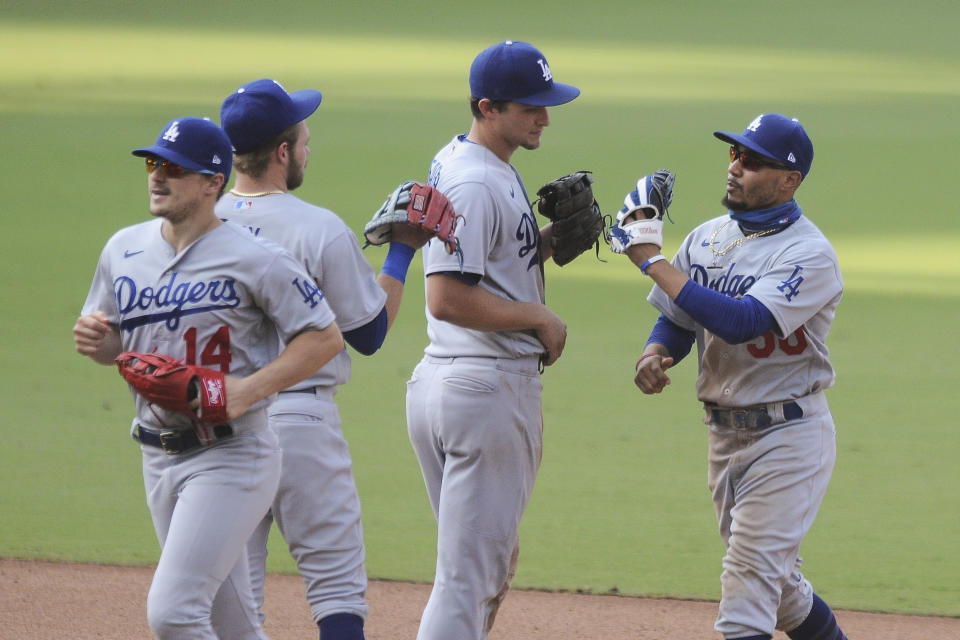 Los Angeles Dodgers shortstop Corey Seager congratulates Mookie Betts, right, after the Dodgers defeated the San Diego Padres in a baseball game Wednesday, Sept. 16, 2020, in San Diego. (AP Photo/Derrick Tuskan)