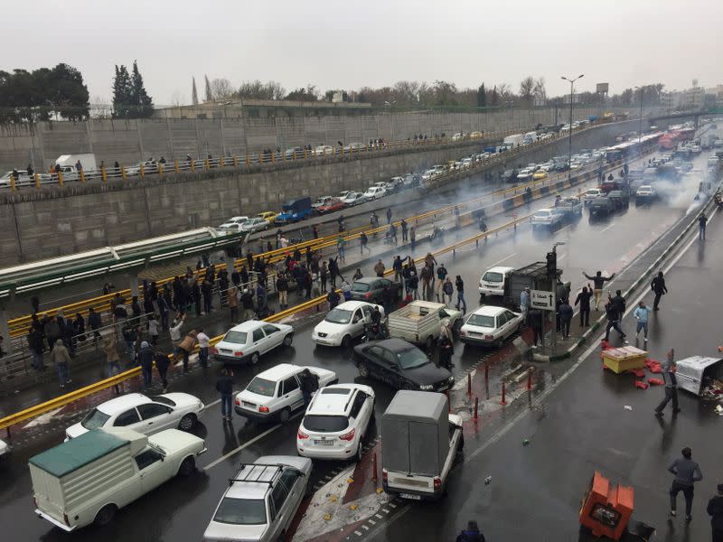 FILE PHOTO: People stop their cars in a highway to show their protest for increased gas price in Tehran