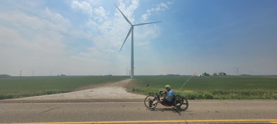 A RAGBRAI route inspection rider passes through a sprawling wind farm in the countryside northwest of Carroll on Monday.