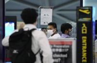 Pyae Lyan Aung, center, a member of the Myanmar national team who raised a three-finger salute during a qualifying match for the 2022 World Cup in late May, arrives at Kansai International Airport in Osaka Prefecture, Japan on Wednesday June 16, 2021. Pyae Lyan Aung has refused to return home and is seeking asylum, a request the government was considering taking into account unrest in his country following a coup.(Kyodo News via AP)