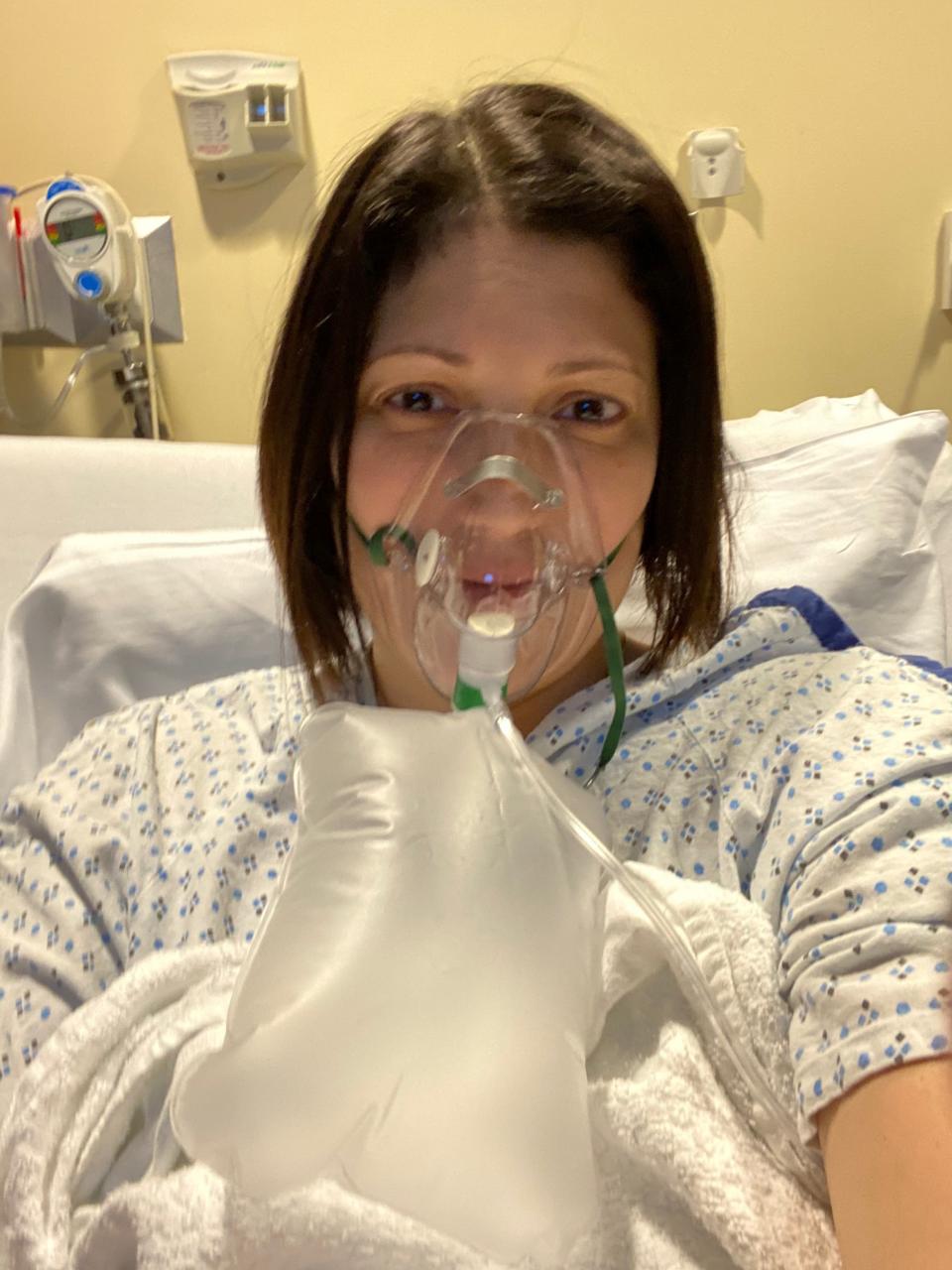 Sofia Burke, 43, of Elmwood Park, uses a non-rebreather mask to deliver high concentrations of oxygen while hospitalized with COVID on Nov. 25, 2020.