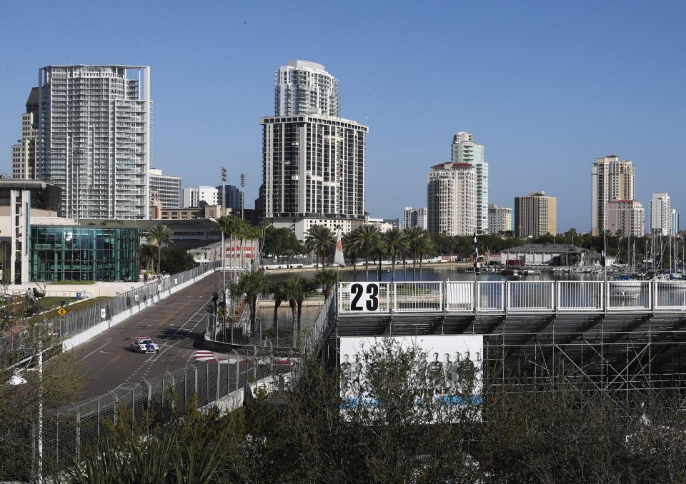 FILE - In this March 13, 2020, file photo, the grandstands are empty as a car passes Mahaffey Theater and heads towards turn 10 during preparation for the IndyCar Grand Prix of St. Petersburg in St. Petersburg, Fla. IndyCar is getting ready for an all-in-one-day season opener on the fast track in Texas, more than 2 ½ months after drivers were set to roll on the streets of St. Pete. The pandemic-delayed season is now set to open Saturday, June 6, 2020. (Dirk Shadd/Tampa Bay Times via AP, File)