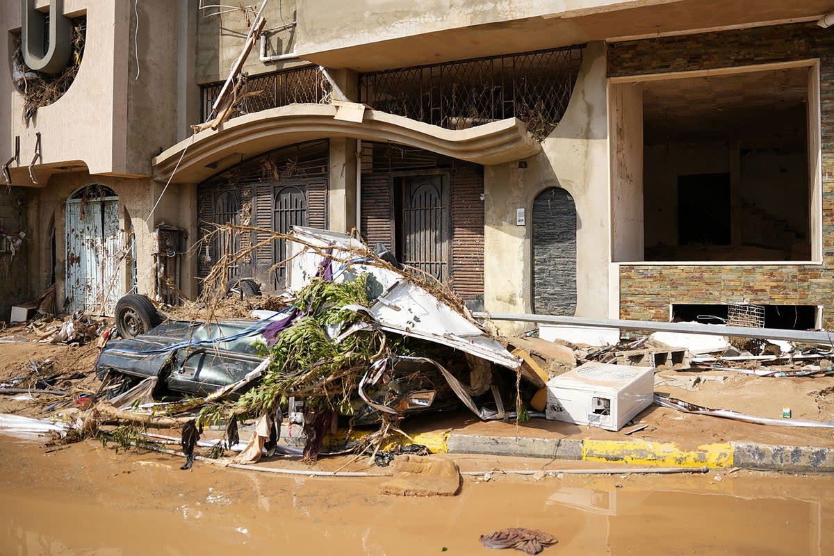 A view of a destroyed vehicle by damaged buildings in Libya’s eastern city of Derna (The Press Office of Libyan Prime)