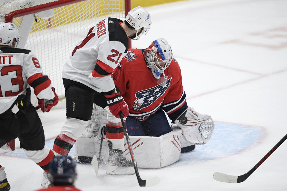 Washington Capitals goaltender Vitek Vanecek, right, stops the puck in front to New Jersey Devils right wing Kyle Palmieri (21) during the second period of an NHL hockey game Tuesday, March 9, 2021, in Washington. (AP Photo/Nick Wass)