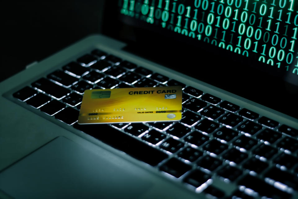 Credit Cards Theft Concept. Hacker with Credit Cards on His Laptop Using Them For Unauthorized Shopping. Photo: Getty