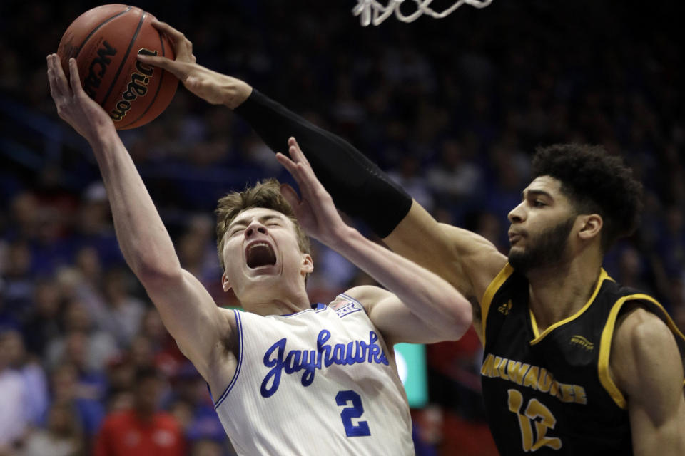 Milwaukee center Amir Allen (12) blocks a shot by Kansas guard Christian Braun (2) during the first half of an NCAA college basketball game in Lawrence, Kan., Tuesday, Dec. 10, 2019. (AP Photo/Orlin Wagner)