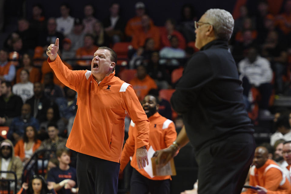 Illinois' coach Brad Underwood signals as Kansas City's coach Marvin Menzies looks on during the first half of an NCAA college basketball game Friday, Nov. 11, 2022, in Champaign, Ill. (AP Photo/Michael Allio)