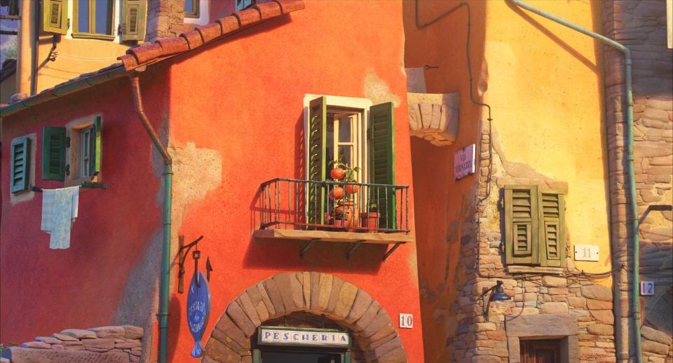 A red colored house with a tomato plant in its balcony.