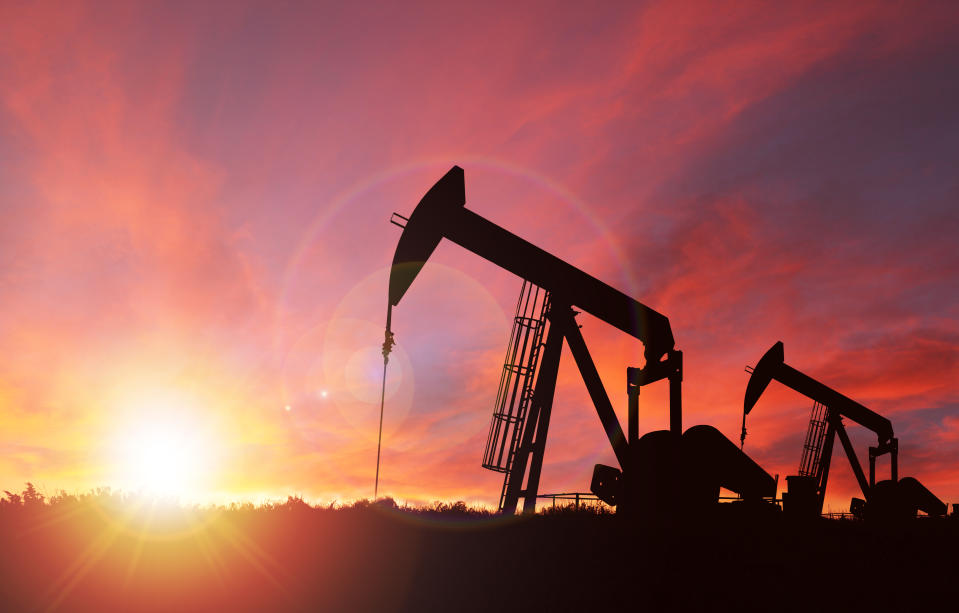 Pump jack silhouette against a sunset sky with deliberate lens flare and copy space. These jacks can extract between 5 to 40 litres of crude oil and water emulsion at each stroke.    This image is made up of 2 photos attached here for reference--one is my image of an Alberta landscape sunset shot in Calgary; the other is my photo of a pump jack shot in rural Alberta and then converted into a silhouette before compositing them together in Photoshop.