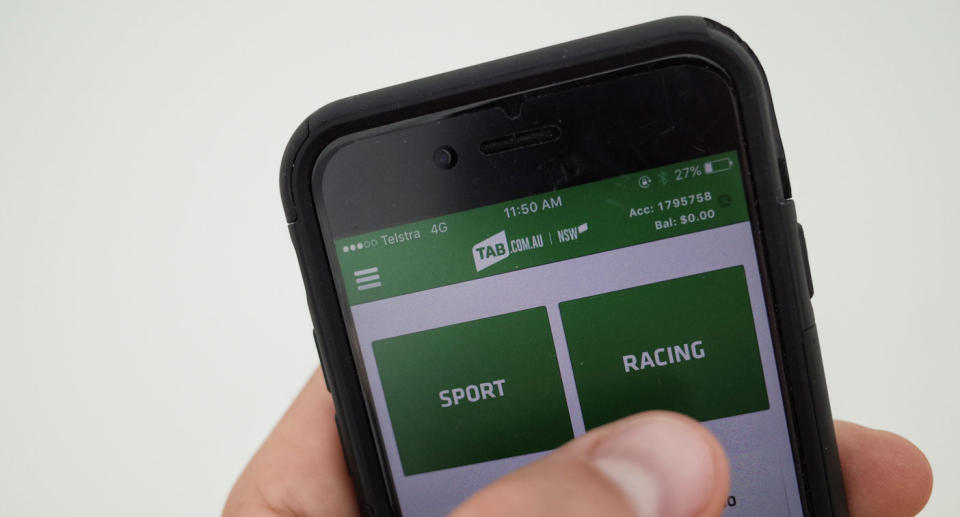 A person uses the TAB app on their iPhone. Batting apps can be used to bet on The Melbourne Cup. Source: AAP.