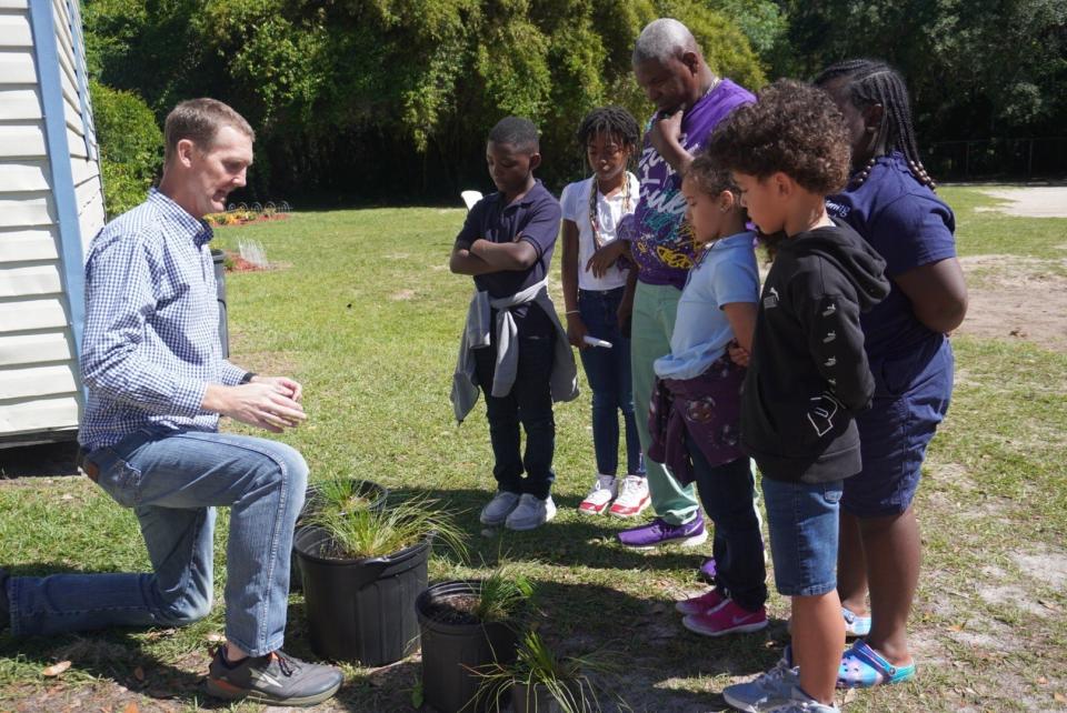 Tom Kay, left, executive director of the Alachua County Conservation Trust, plants trees along with students and staff on Monday during an Earth Day program at Caring and Sharing Learning School in Gainesville.
(Credit: Photo provided by Voleer Thomas)