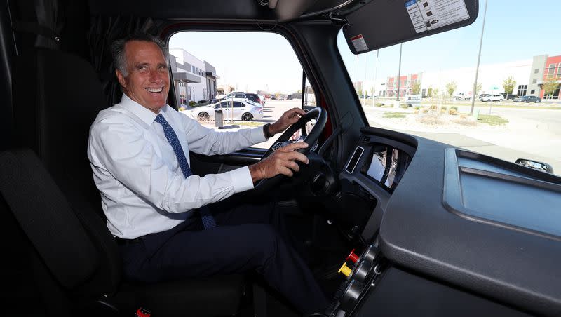 Sen. Mitt Romney, R-Utah, smiles as he gets into the driver’s seat of a Freightliner semi at Double D Distribution in Salt Lake City on April 20, 2022.