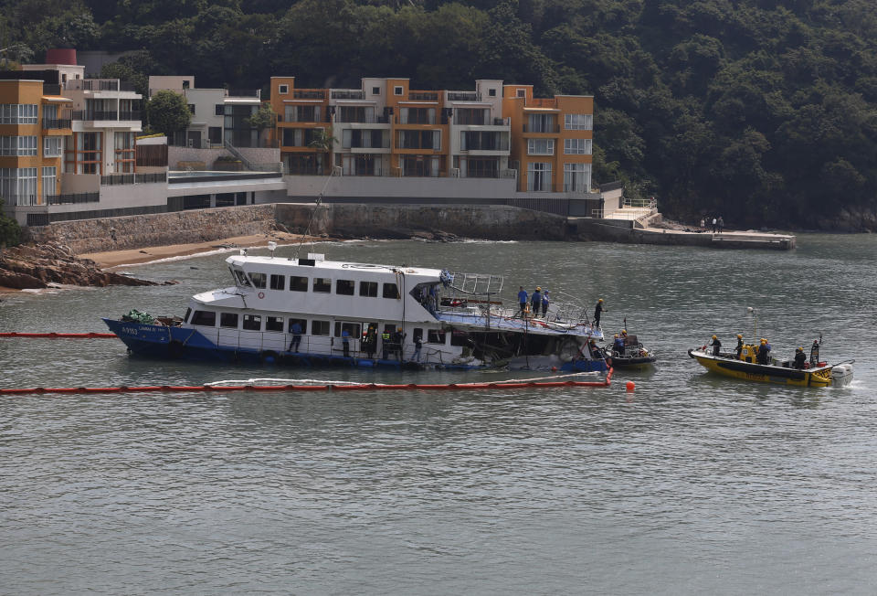 A group of firemen and police officers investigate on a salvaged boat which sank after colliding with a ferry near Lamma Island, off the southwestern coast of Hong Kong Island Wednesday, Oct. 3, 2012. An official with the ferry company involved in the collision that killed 38 people said Wednesday that the vessel recently passed inspection, but he had no details about how the crash occurred. (AP Photo/Kin Cheung)