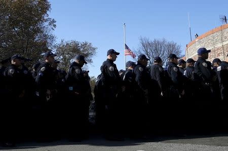 Members of the New York City Police Department (NYPD) newly formed Critical Response Command anti-terrorism unit stand beneath an American flag flying at half staff in honor of the victims of the attacks in Paris as they gather for their first deployment outside their headquarters on Randall's Island in New York City, November 16, 2015. REUTERS/Mike Segar