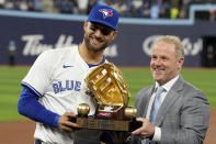 Toronto Blue Jays' Kevin Kiermaier, left, receives his golden glove award from Steve Cohen, director of pro baseball services at Rawlings, during a ceremony prior to a baseball game against the Colorado Rockies in Toronto, Friday, April 12, 2024. (Frank Gunn/The Canadian Press via AP)