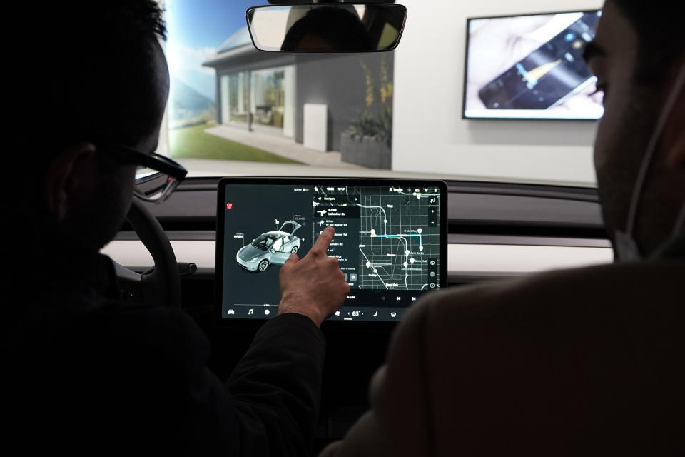 FILE - Customers look over a Tesla Model Y Long-range on display at the Tesla Gallery on Feb. 24, 2021, in Troy, Mich. The top U.S. transportation official says Tesla shouldn’t call its partially automated driving system Autopilot because the cars can’t drive themselves. “I don't think that something should be called, for example, an Autopilot, when the fine print says you need to have your hands on the wheel and eyes on the road at all times,” Buttigieg said in an interview with The Associated Press. Texas-based Tesla hasn't returned messages left Thursday, May 11, 2023, seeking comment. (AP Photo/Carlos Osorio, File)