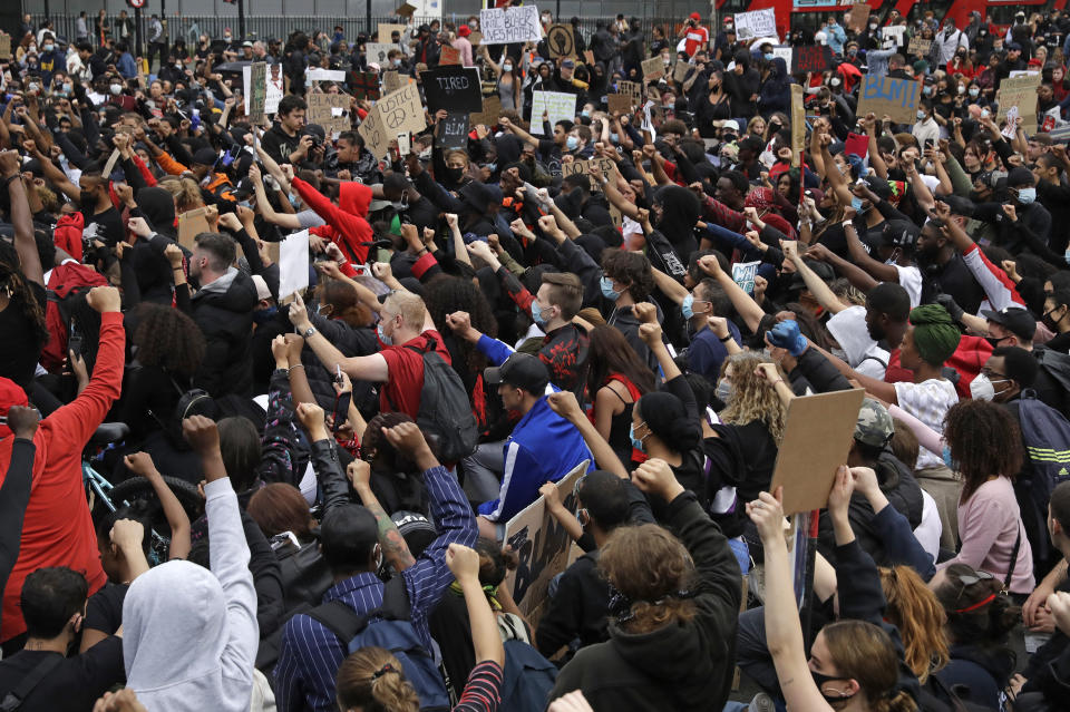 Protesters kneel as they stop briefly in Parliament Square during a demonstration on Wednesday, June 3, 2020, in London, over the death of George Floyd, a black man who died after being restrained by Minneapolis police officers on May 25. Protests have taken place across America and internationally, after a white Minneapolis police officer pressed his knee against Floyd's neck while the handcuffed black man called out that he couldn't breathe. The officer, Derek Chauvin, has been fired and charged with murder. (AP Photo/Matt Dunham)