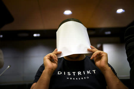 The 24-year-old Moroccan Abdederrazak Essarioul, covers his face during the initial remand hearing of suspects in the stabbing attack in Turku last week, at the Southwest Finland District Court in Turku, Finland, August 22, 2017. LEHTIKUVA / Martti Kainulainen via REUTERS