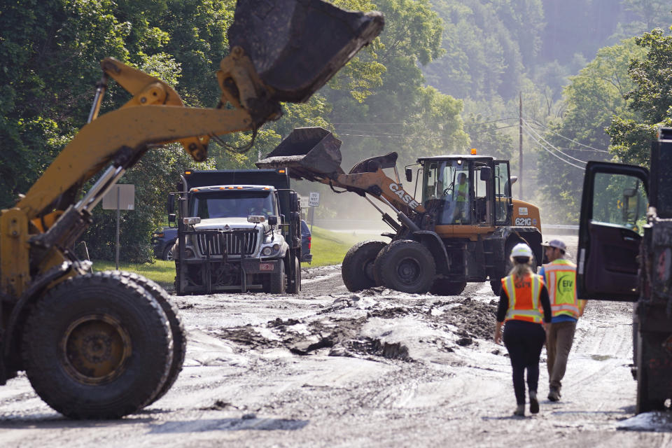 Loaders clear mud from a road leading to downtown, Wednesday, July 12, 2023, in Montpelier, Vt. Following a storm that dumped nearly two months of rain in two days, Vermonters are cleaning up from the deluge of water. (AP Photo/Charles Krupa)