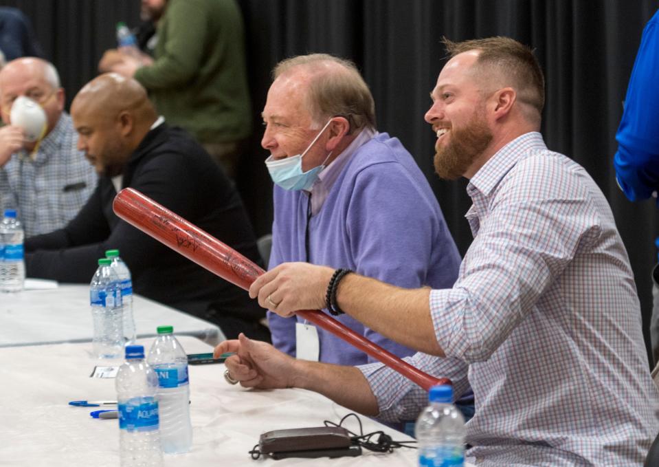 Aaron Barrett (far right) hands back a signed baseball bat during the Night of Memories on Saturday at Meeks Auditorium on the University of Evansville campus.
