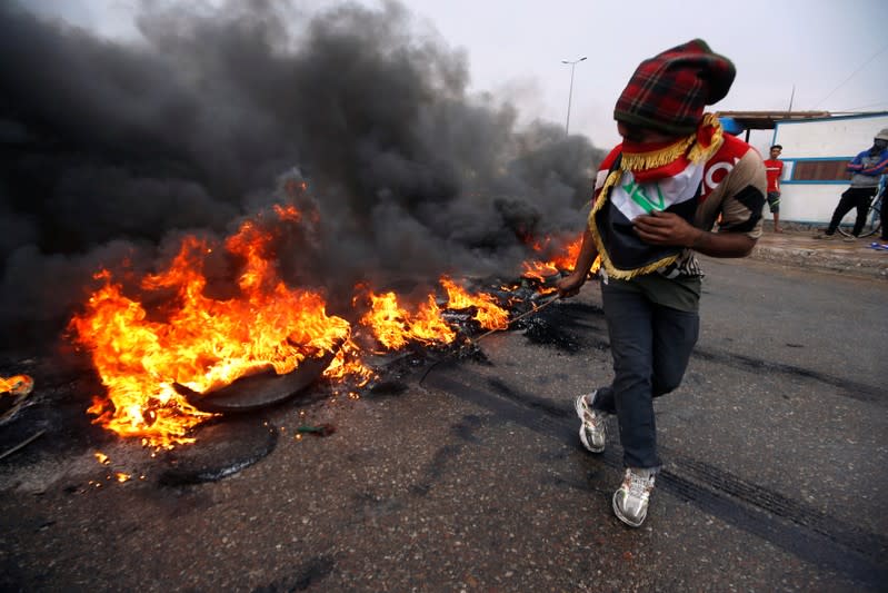 Iraqi protesters burn tires during the ongoing anti-government protests in Basra