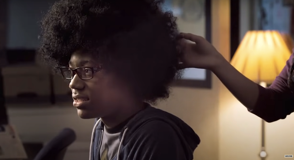 Someone touches young man's afro