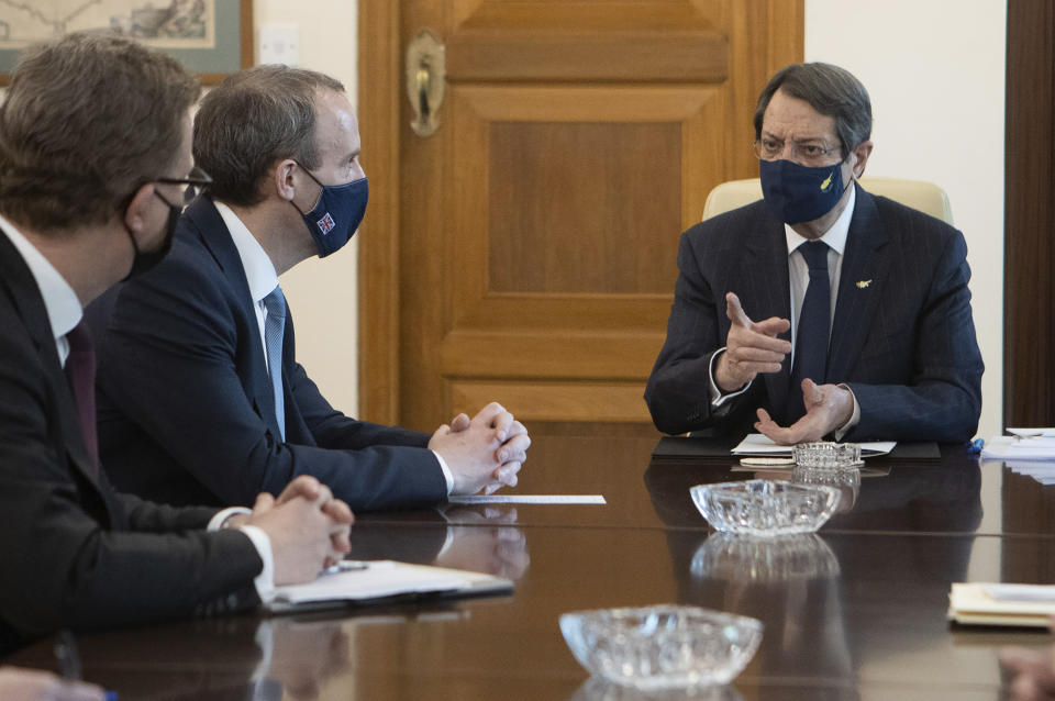 In this photo provided from Cyprus press and information office, Cyprus President Nicos Anastasiades, right, talks with Britain's Secretary of State for Foreign Affairs, Dominic Raab, during their meeting at the presidential palace in capital Nicosia, Cyprus, Thursday, Feb. 4, 2021. Raab is in Cyprus for one day of talks. (Stavros Ioannides / PIO via AP)