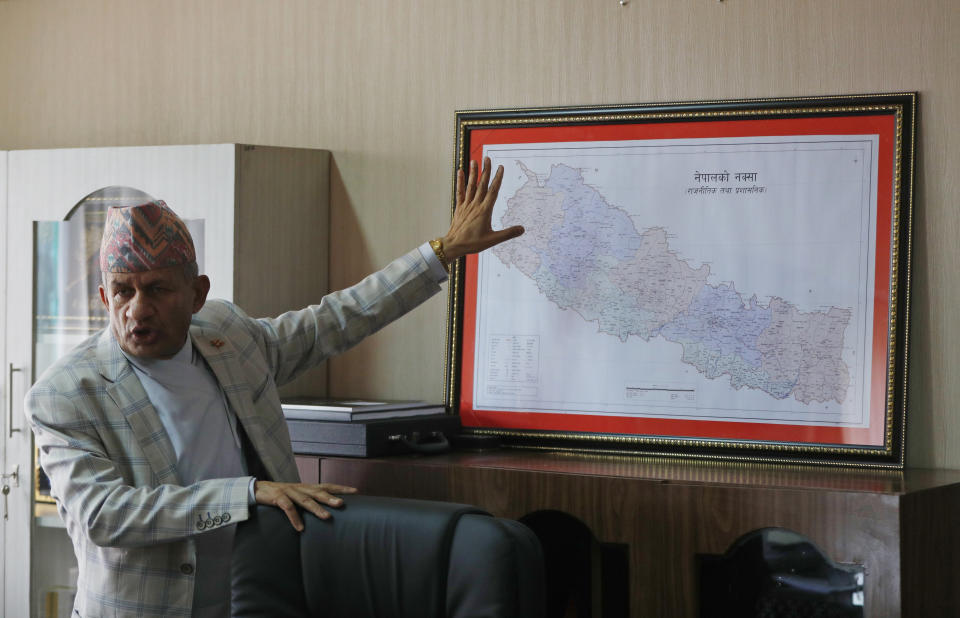 FILE - In this Tuesday, June 9, 2020, file photo, Nepal's Foreign Minister Pradeep Gyawali points to a map of Nepal during an interview with the Associated Press in Kathmandu, Nepal. Nepal’s parliament overwhelmingly approved a constitution amendment on Saturday to change the nation’s map that includes territory claimed by both Nepal and India which is likely to anger New Delhi. House of Representatives speaker Agni Kharel announced that all 258 members who were present on Saturday voted in favor of the constitution amendment proposal. The amendment proposal needed two-third of the 275 total seats in the parliament. (AP Photo/Niranjan Shrestha, File)