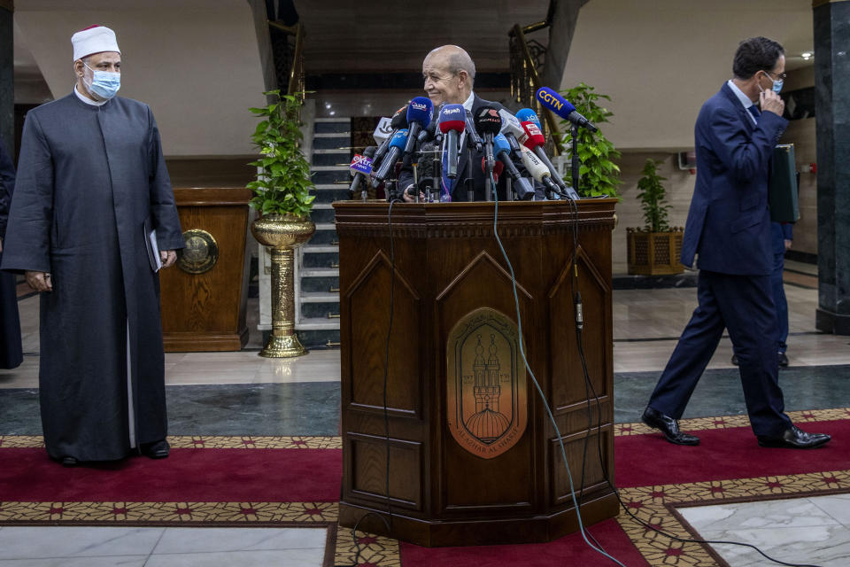 French Foreign Minister Jean-Yves Le Drian, center, smiles at Deputy Head of Al-Azhar Mohammed el-Doweiny before speaking at a press conference at the headquarters of Al Azhar, in Cairo, Egypt, Sunday, Nov. 8, 2020. Le Drian visited Cairo on Sunday to meet with political and religious leaders in an effort to calm tensions and misunderstandings with the Arab and Muslim world following anti-French protests and three Islamic extremist attacks on France. (AP Photo/Nariman El-Mofty)