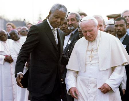 South African President Nelson Mandela (L) guides Pope John Paul II after they met at Johannesburg International Airport, at the start of the pope's first official visit to the country, in this file picture taken September 16, 1995. REUTERS/Patrick De Noirmont/Files